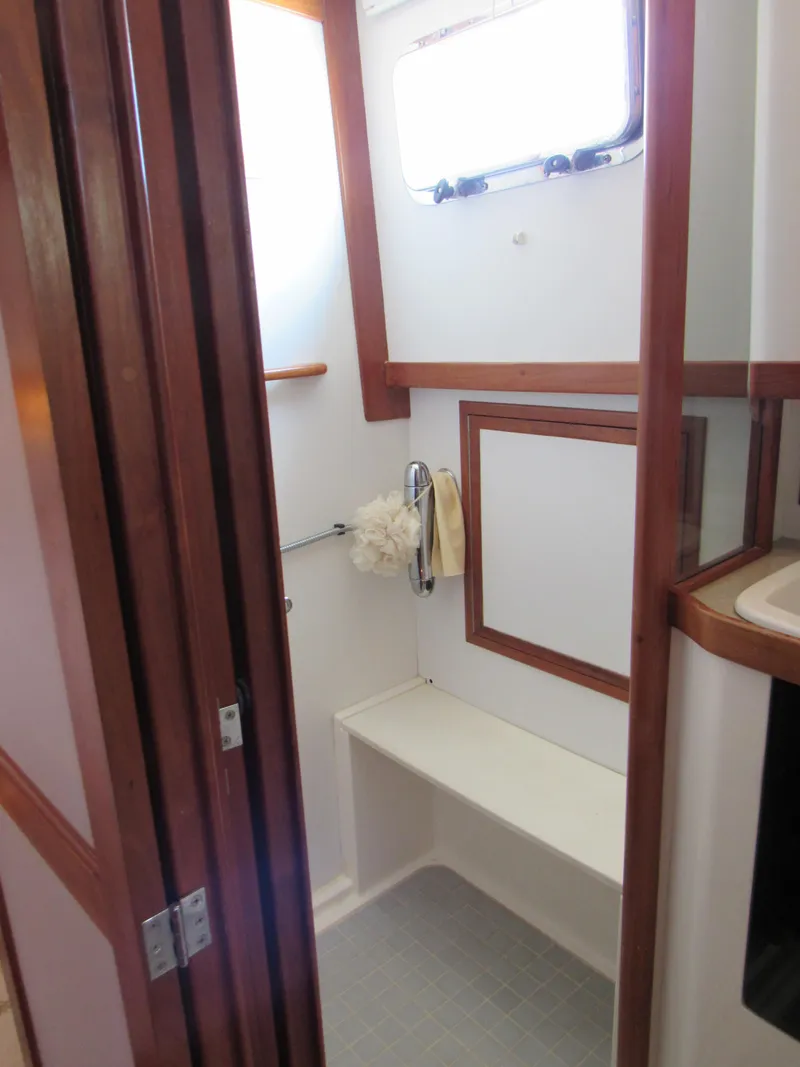 Slide: The Image of 1999 Sabre Sabreline 47 yacht bathroom with wooden trim and window. - 21