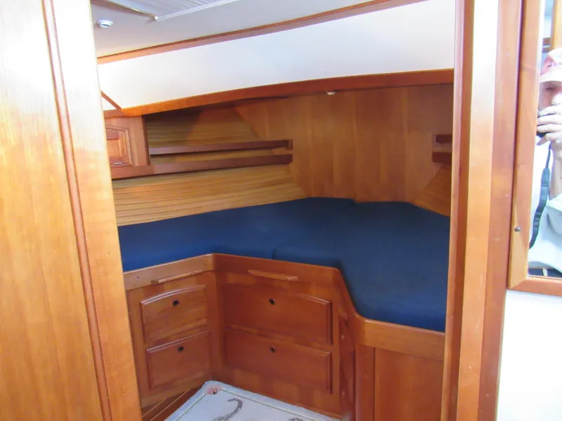Slide: The Image of 1999 Sabreline 47 yacht cabin with wooden interior and blue bedding. - 23