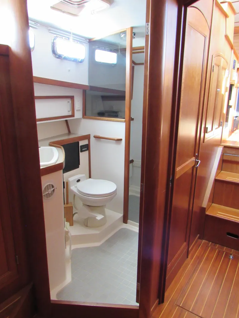 Slide: The Image of 1999 Sabreline 47 yacht bathroom with wooden cabinetry and modern fixtures. - 24