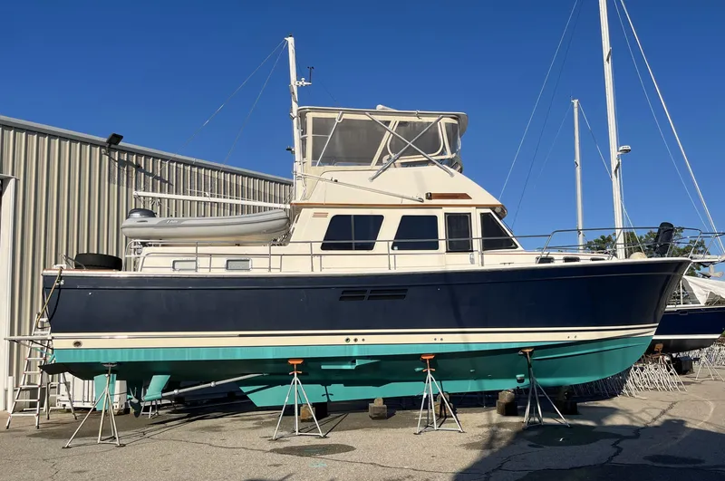 Slide: The Image of 1999 Sabre Sabreline 47 yacht on stands, blue and white hull, docked outdoors. - 25