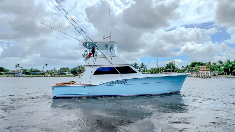 Slide: The Image of 1982 Hatteras 46 Convertible yacht on calm water under cloudy sky. - 11