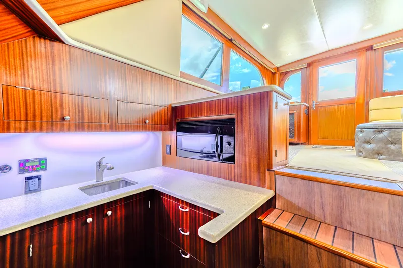 Slide: The Image of Luxurious 1982 Hatteras 46 Convertible yacht interior with modern kitchen and wooden cabinetry. - 15