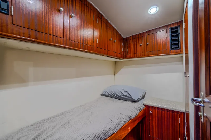 Slide: The Image of Cozy cabin interior of 1982 Hatteras 46 Convertible yacht with wooden cabinetry and single bed. - 17