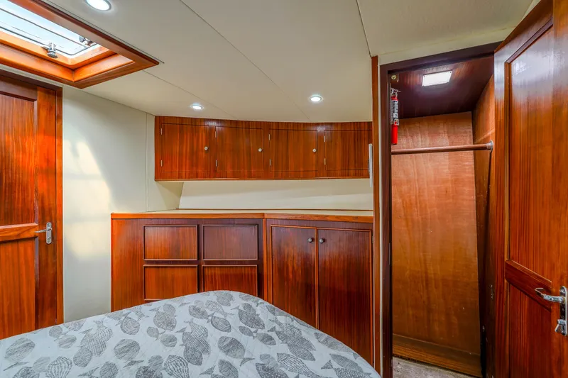 Slide: The Image of Interior of 1982 Hatteras 46 Convertible yacht with wooden cabinetry and cozy bedroom. - 22