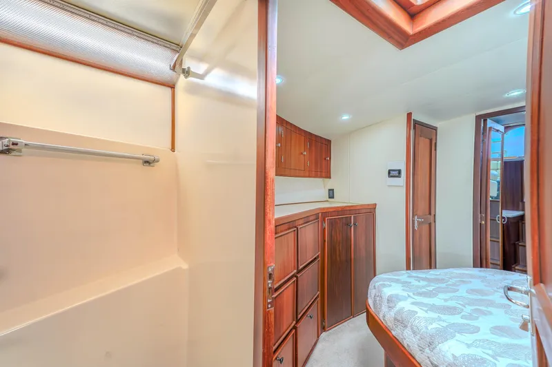 Slide: The Image of Interior of 1982 Hatteras 46 Convertible yacht with wood cabinetry and cozy sleeping area. - 25