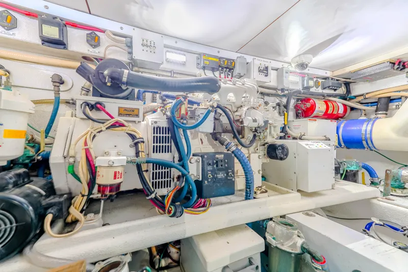 Slide: The Image of Engine room of 1982 Hatteras 46 Convertible yacht, showcasing complex machinery and wiring. - 33