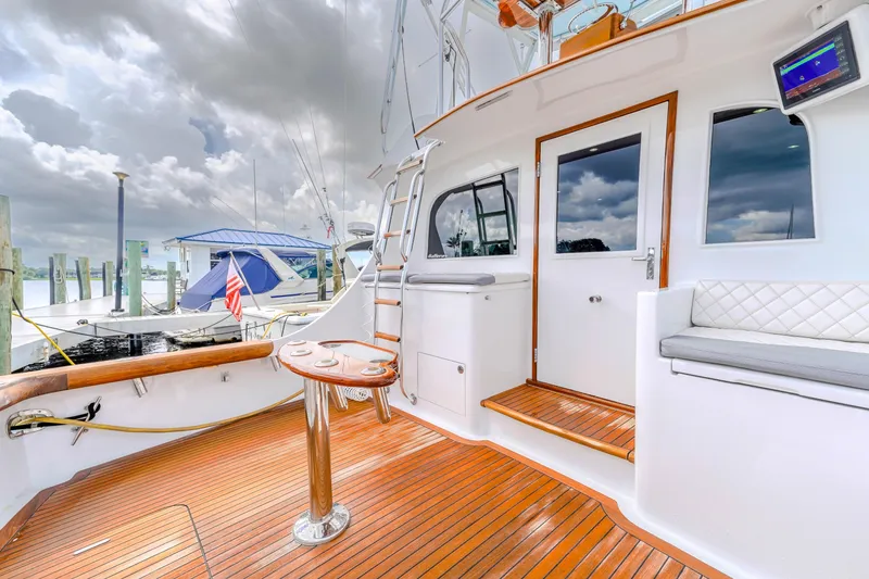 Slide: The Image of 1982 Hatteras 46 Convertible yacht with wooden deck and seating area. - 34