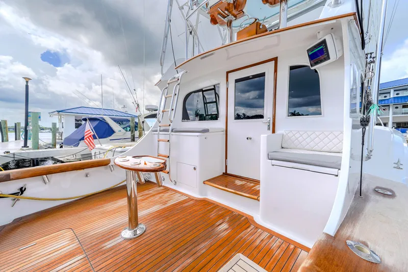 Slide: The Image of 1982 Hatteras 46 Convertible yacht with polished wood deck and seating area. - 36