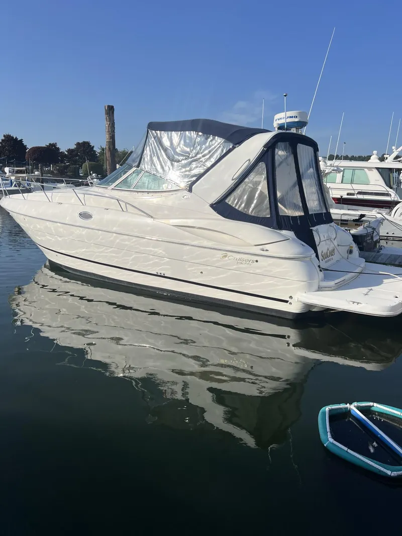 Slide: The Image of 2004 Cruisers Yachts 320 Express boat docked in marina, clear blue sky. - 2