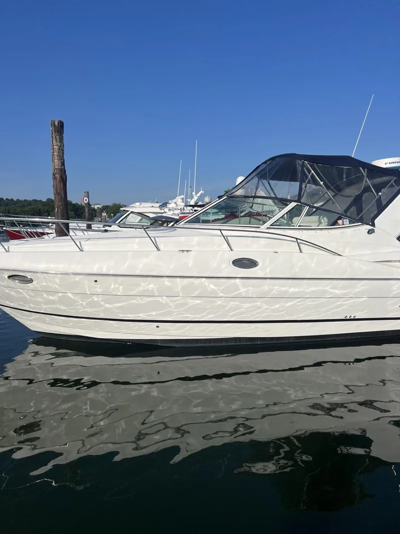 Slide: The Image of 2004 Cruisers Yachts 320 Express boat docked on calm water. - 3