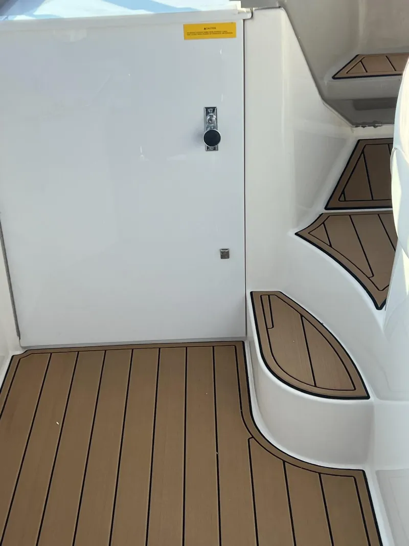 Slide: The Image of 2004 Cruisers Yachts 320 Express interior with wood-patterned flooring and steps. - 7
