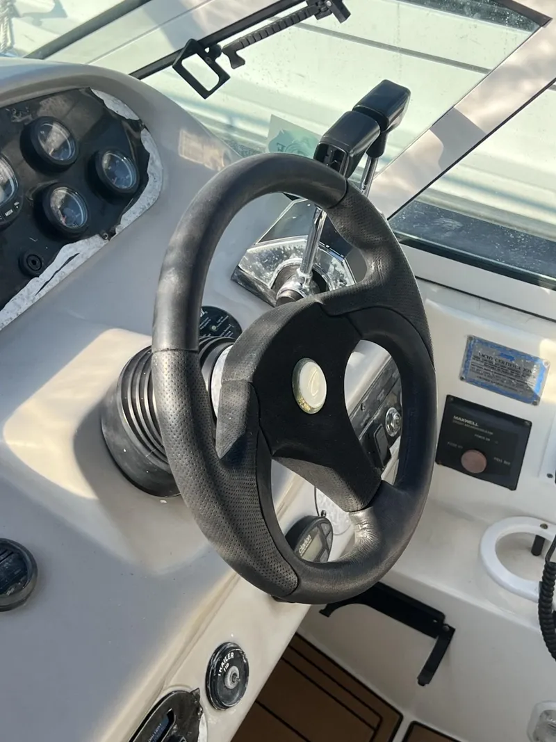 Slide: The Image of 2004 Cruisers Yachts 320 Express helm with steering wheel and control panel. - 9