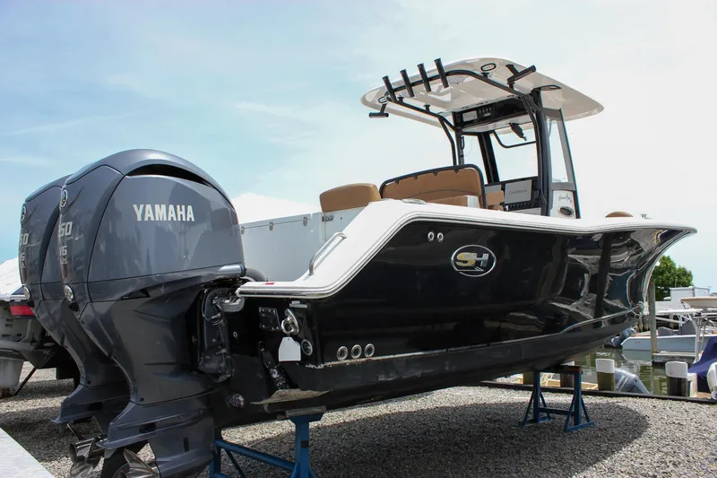 Slide: The Image of 2022 Sea Hunt Gamefish 27 boat with Yamaha engine, displayed on stands. - 0