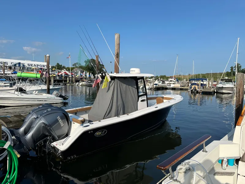 Slide: The Image of 2022 Sea Hunt Gamefish 27 boat docked at marina, clear sky, calm water. - 1