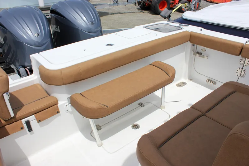Slide: The Image of 2022 Sea Hunt Gamefish 27 boat interior with brown seating and dual engines. - 10