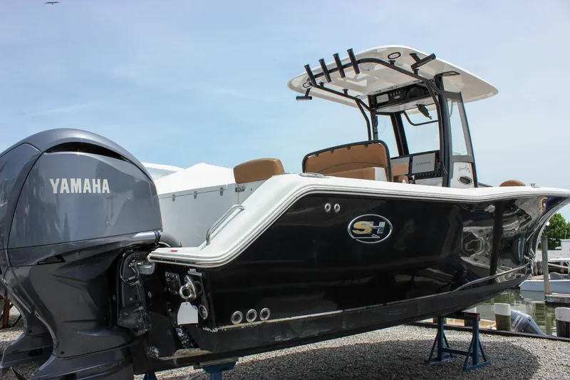 Slide: The Image of 2022 Sea Hunt Gamefish 27 Forward Seating boat with Yamaha engine, displayed on a stand. - 11