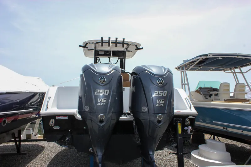 Slide: The Image of 2022 Sea Hunt Gamefish 27 with twin Yamaha 250 V6 engines, displayed at a boat show. - 2