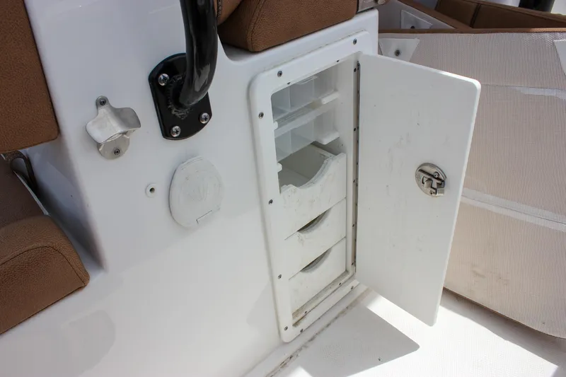 Slide: The Image of 2022 Sea Hunt Gamefish 27 storage compartment with open door and seating area. - 31