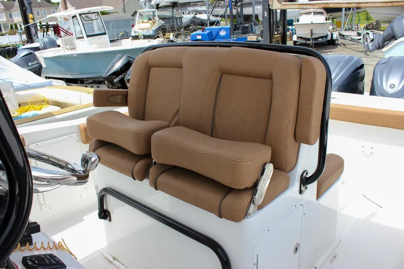 Slide: The Image of 2022 Sea Hunt Gamefish 27 Forward Seating with brown cushioned seats in a marina setting. - 34