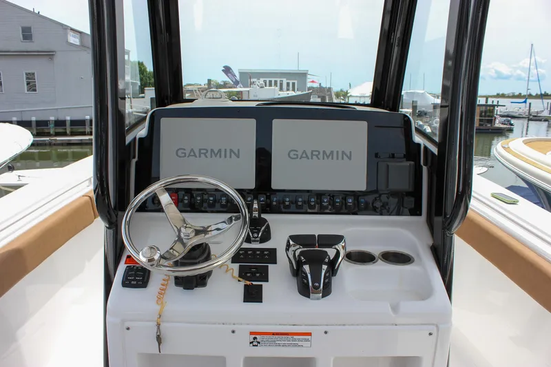 Slide: The Image of 2022 Sea Hunt Gamefish 27 helm with Garmin displays and steering wheel. - 5