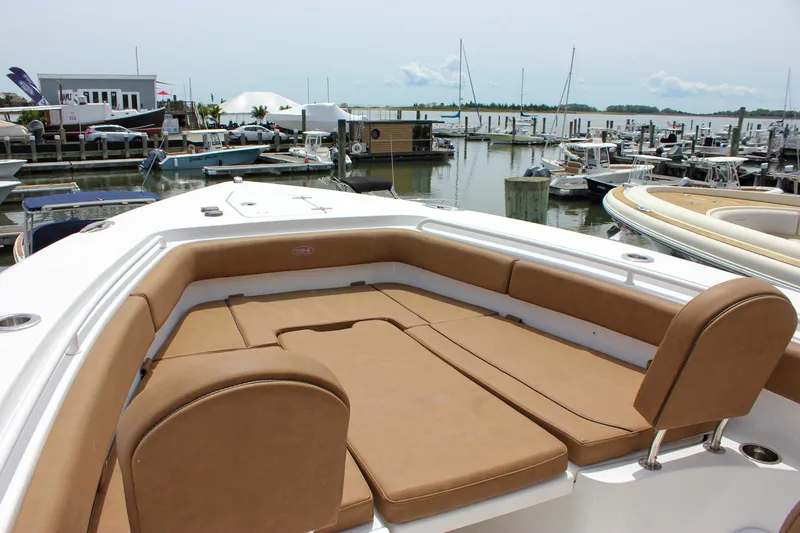 Slide: The Image of 2022 Sea Hunt Gamefish 27 Forward Seating boat at marina, featuring tan cushioned seating. - 6