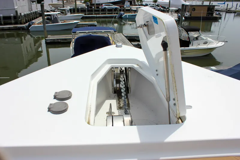 Slide: The Image of 2022 Sea Hunt Gamefish 27 Forward Seating boat anchor compartment open at marina. - 9