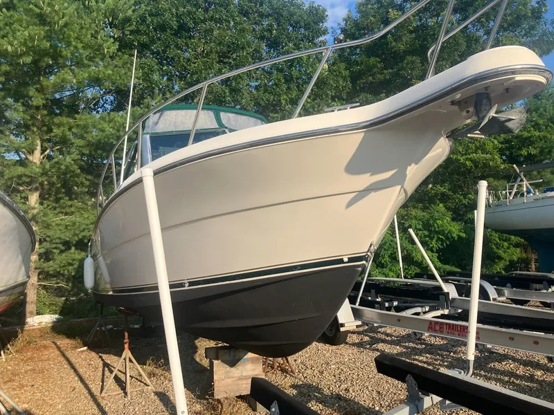 Slide: The Image of 1998 Pursuit 2860 Denali boat on dry dock, surrounded by trees and trailers. - 3