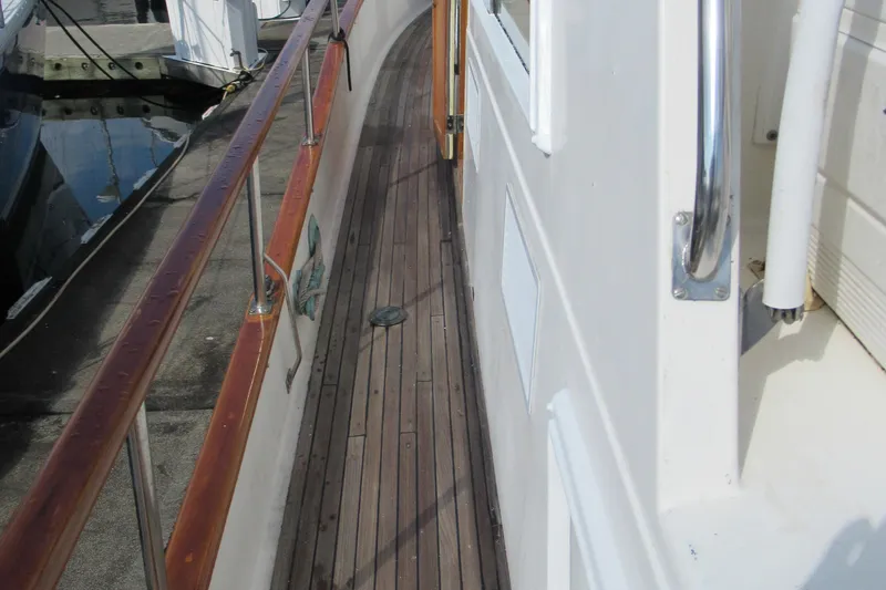 Slide: The Image of 1985 Grand Banks 42 Classic yacht deck with wooden railings and walkway. - 27