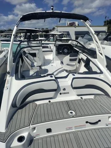 Slide: The Image of 2019 Yamaha Boats 242 Limited S E-Series, sleek design, spacious interior, docked under blue sky. - 30