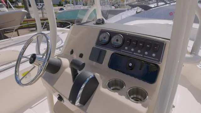 Slide: The Image of 2024 Boston Whaler 210 Montauk boat dashboard with steering wheel and controls. - 11