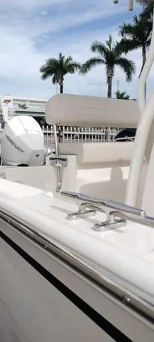Slide: The Image of 2024 Boston Whaler 210 Montauk boat with Mercury engine, docked near palm trees. - 21