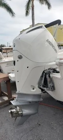 Slide: The Image of 2024 Boston Whaler 210 Montauk with Mercury outboard motor, docked near palm trees. - 23