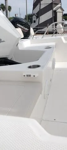 Slide: The Image of 2024 Boston Whaler 210 Montauk boat interior with Mercury engine and lighthouse in background. - 25