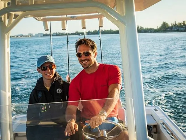 Slide: The Image of Two people enjoying a ride on a 2024 Boston Whaler 210 Montauk boat. - 33