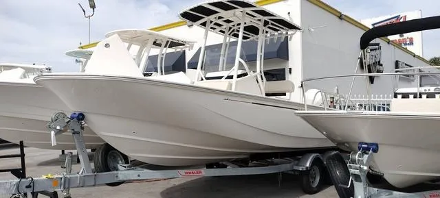Slide: The Image of 2024 Boston Whaler 210 Montauk boat on trailer, displayed outdoors. - 6
