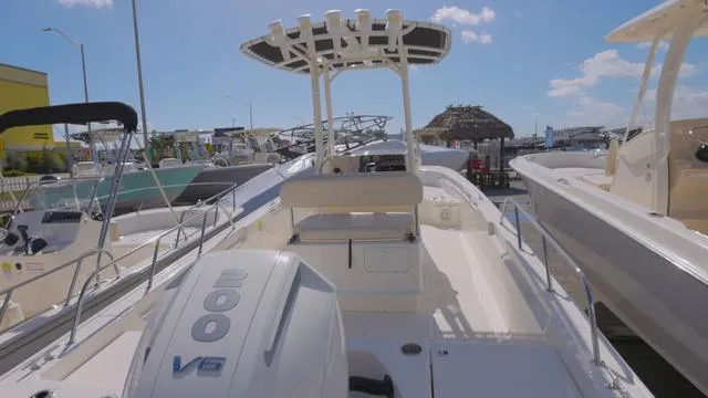 Slide: The Image of 2024 Boston Whaler 210 Montauk boat with powerful V8 engine, docked under clear skies. - 9