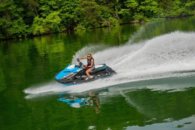 Slide: The Image of 2024 Yamaha Waverunner GP HO™ with Audio speeding on a lush green lake. - 16