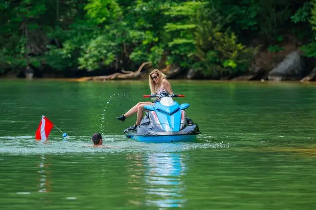 Slide: The Image of 2024 Yamaha Waverunner GP HO with Audio on a lake, woman riding, swimmer nearby. - 32