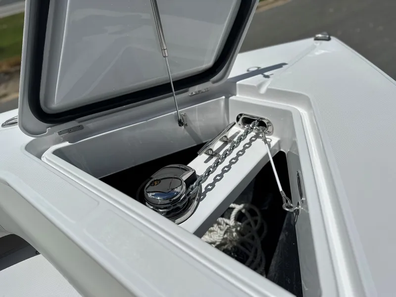 Slide: The Image of Open anchor compartment on 2025 Jupiter 32 boat, showcasing chain and storage. - 11