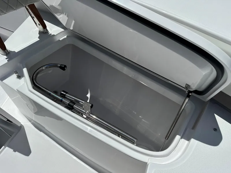 Slide: The Image of Open storage compartment on 2025 Jupiter 32 boat with metal handle inside. - 13