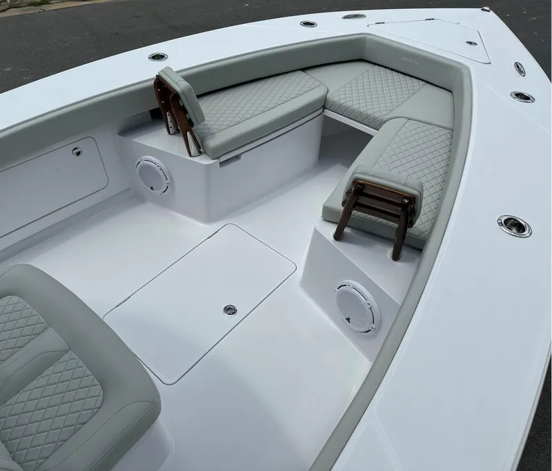 Slide: The Image of 2025 Jupiter 32 boat interior with cushioned seating and speakers. - 2