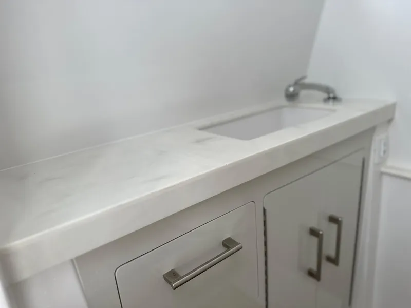 Slide: The Image of Modern white bathroom vanity with sleek faucet and storage cabinets, Jupiter 32 model, 2025. - 21