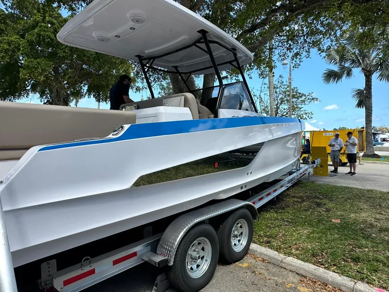 Slide: The Image of 2025 STERK 31 WB Sport boat on trailer, displayed outdoors under trees. - 10