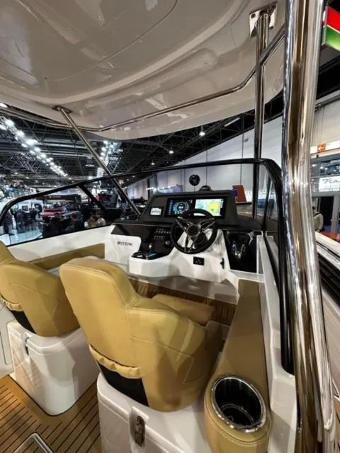 Slide: The Image of 2025 STERK 31 WB Sport boat interior with modern dashboard and beige seating. - 25