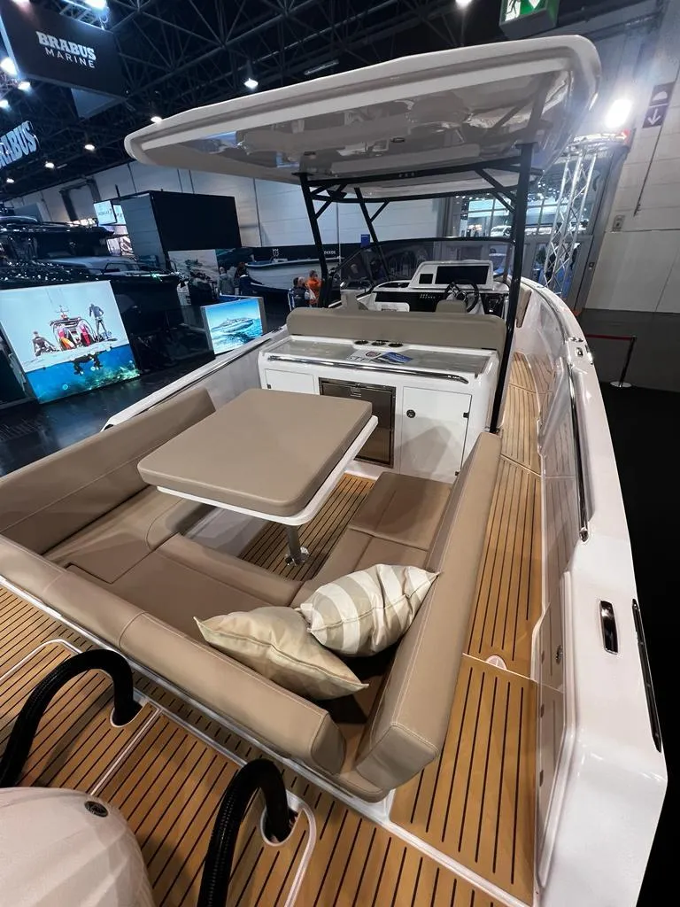 Slide: The Image of 2025 STERK 31 WB Sport boat with sleek seating and modern design at a boat show. - 41