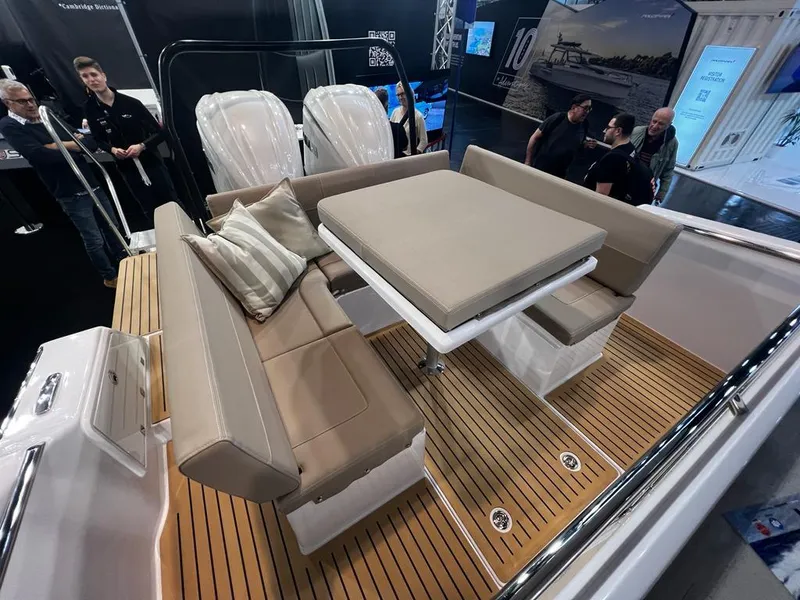 Slide: The Image of 2025 STERK 31 WB Sport boat with cushioned seating and teak deck at a boat show. - 47