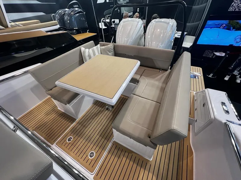 Slide: The Image of 2025 STERK 31 WB Sport boat interior with beige seating and wooden flooring. - 48