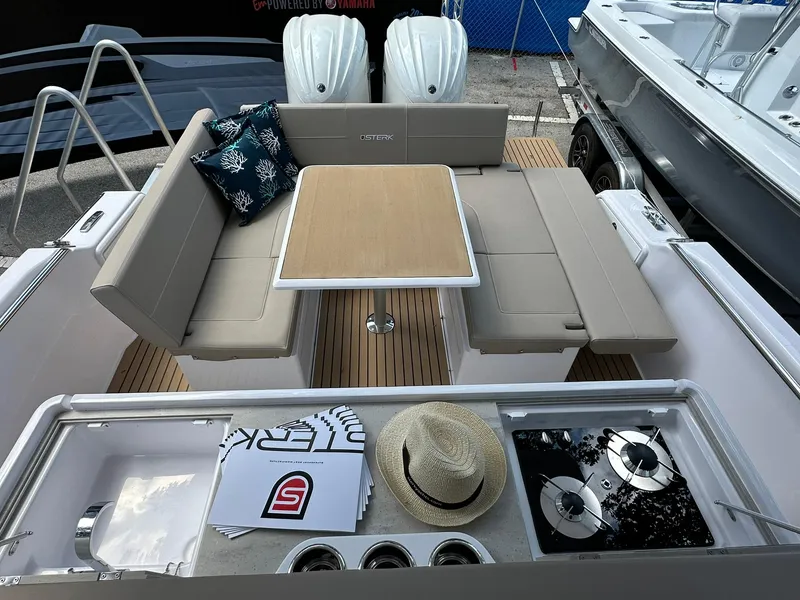 Slide: The Image of 2025 STERK 31 WB Sport boat interior with seating, table, and kitchenette. - 7