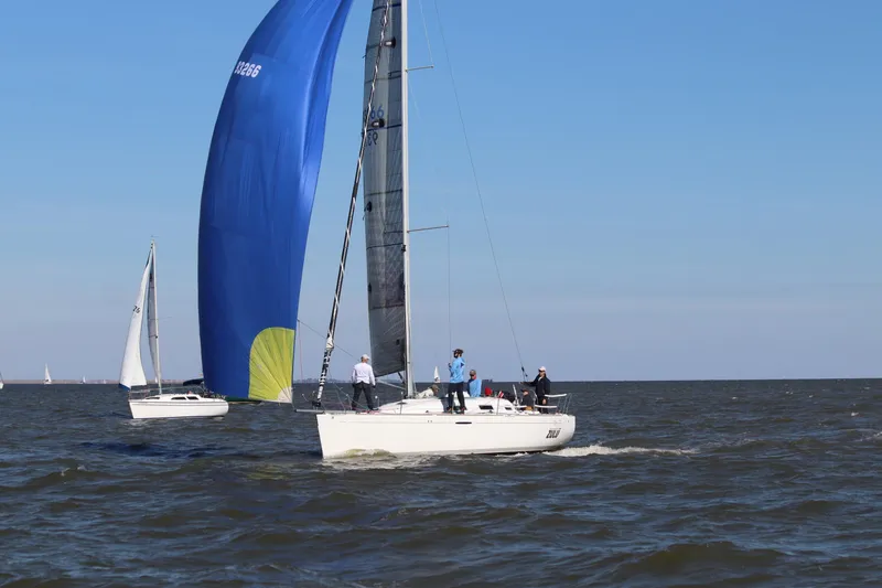 Slide: The Image of Sailing on a 2002 Beneteau First 36.7 with blue spinnaker on open water. - 2