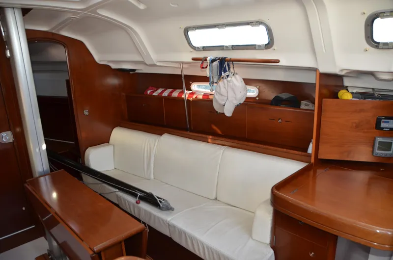 Slide: The Image of Interior of 2002 Beneteau First 36.7 sailboat with white seating and wooden cabinetry. - 22